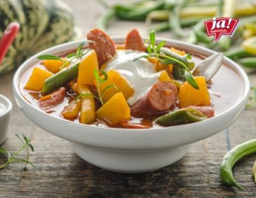 Kürbisgulasch mit Fisolen, Debrezinern und Kümmelrahm Kürbisgulasch mit Fisolen, Debrezinern und Kümmelrahm