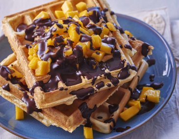 Waffeln mit Schokoladensauce und Mangowürfeln Waffeln mit Schokoladensauce und Mangowürfeln