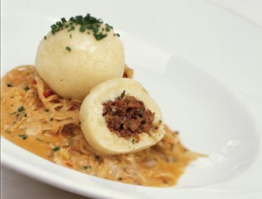 Grammelknöderl auf feinem Krautsalat mit Speck